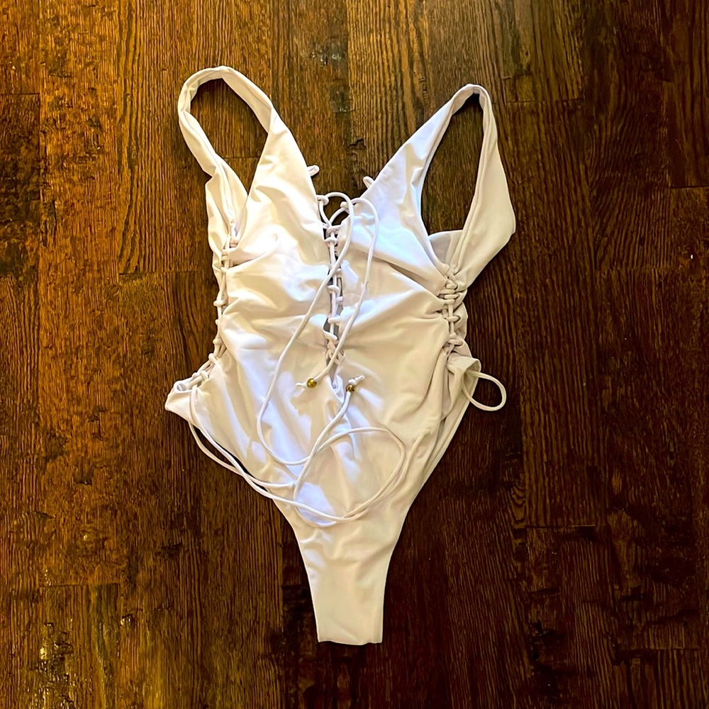 White one piece with side ties and front lace up detail